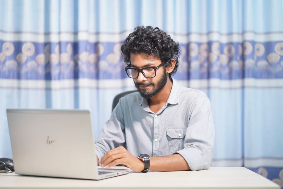 Mengapa WordPress Jadi Pilihan Utama Para Developer Web Profesional? Seorang web developer profesional menunjukkan layar komputer dengan logo WordPress, menjelaskan mengapa Web Developer Profesional Sangat Menyarankan WordPress kepada klien.